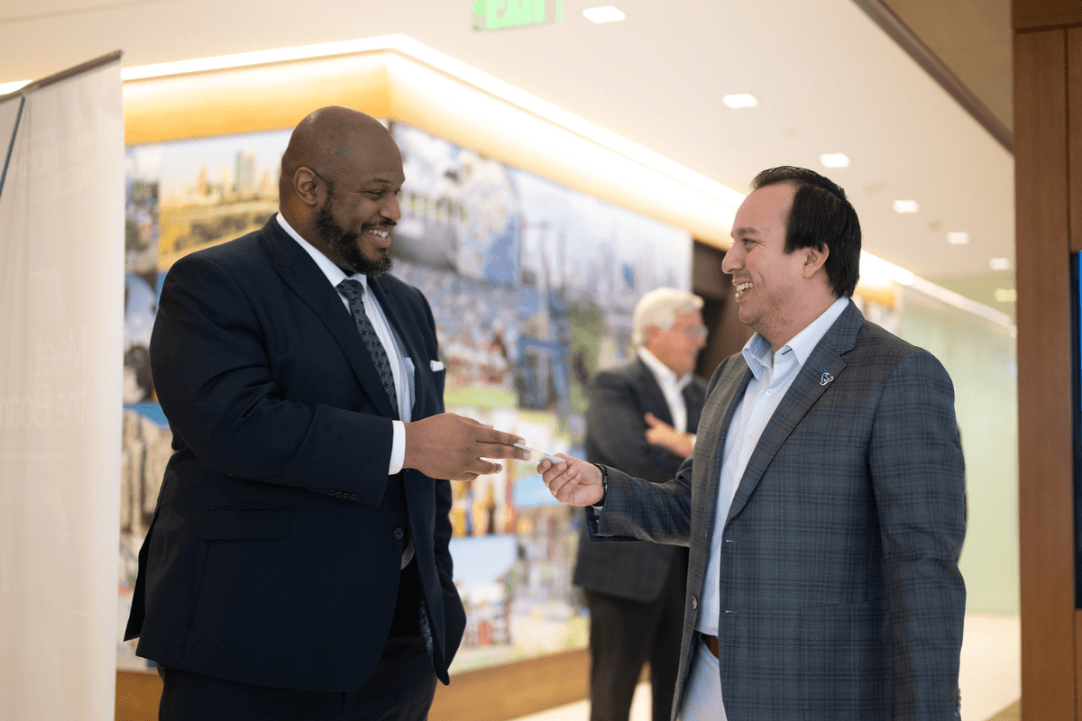 Partnership members exchanging business cards at an event.
