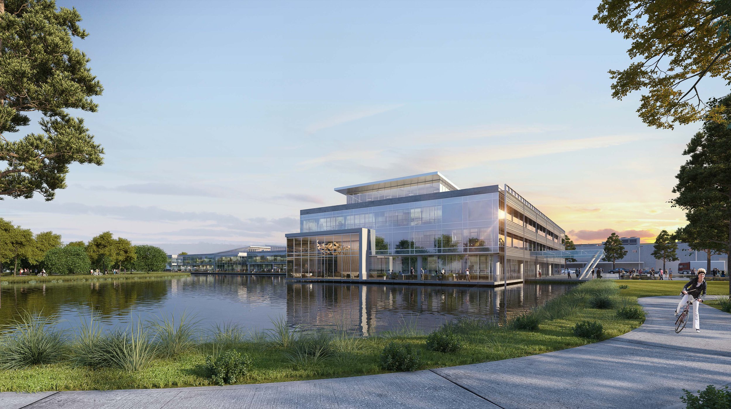 The building is surrounded by lush greenery and trees, with a pathway where a person is riding a bicycle. People can be seen walking and enjoying the outdoor space, and the building features large windows reflecting the serene water and sky.